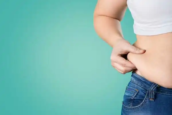 Image of woman pinching her love handles to show weight gain Cheltenham